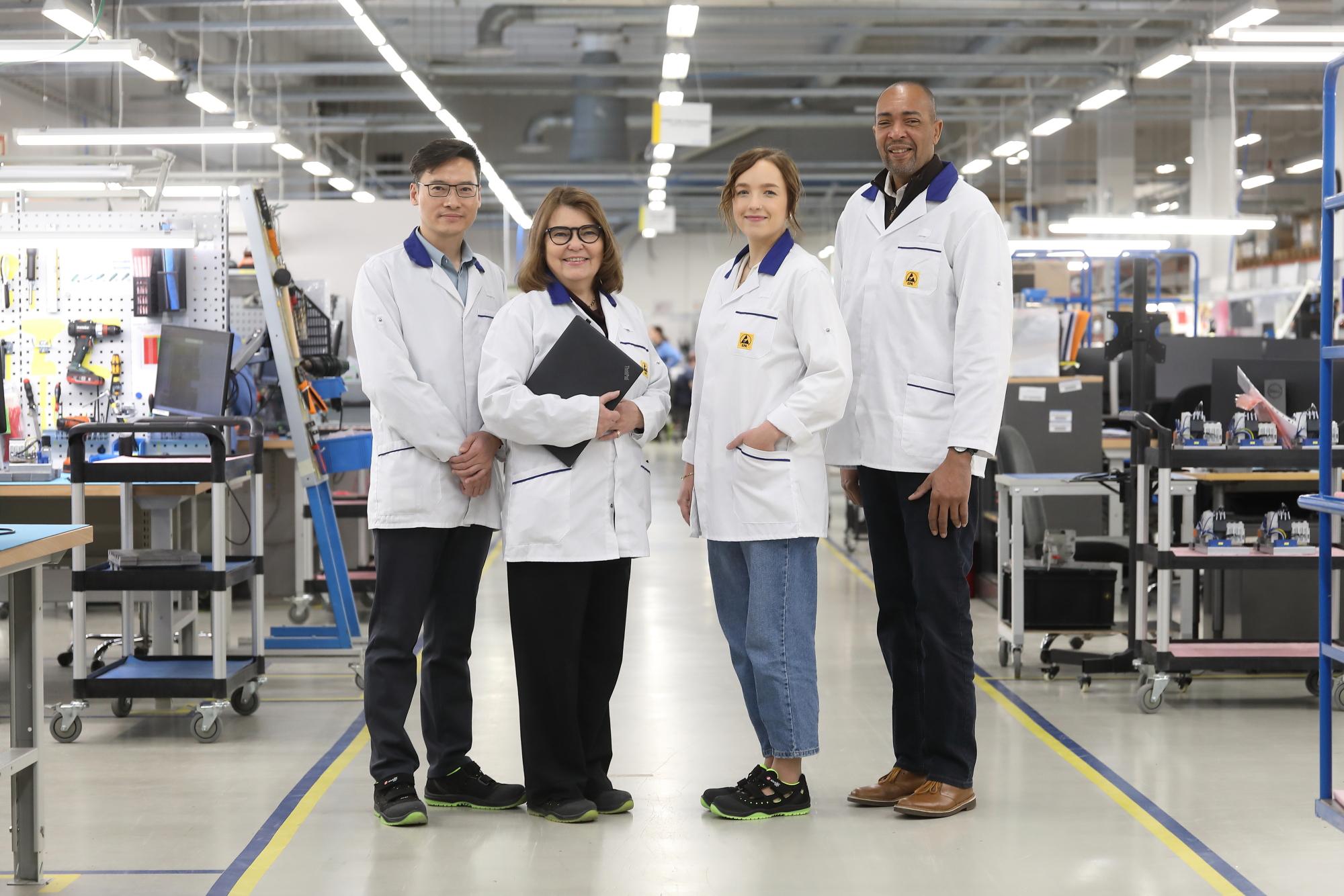 Four Scanfil employees at modern and highly equipped Scanfil factory. Scanfil’s committed and highly skilled employees ensure top‑tier quality at every stage of manufacturing.