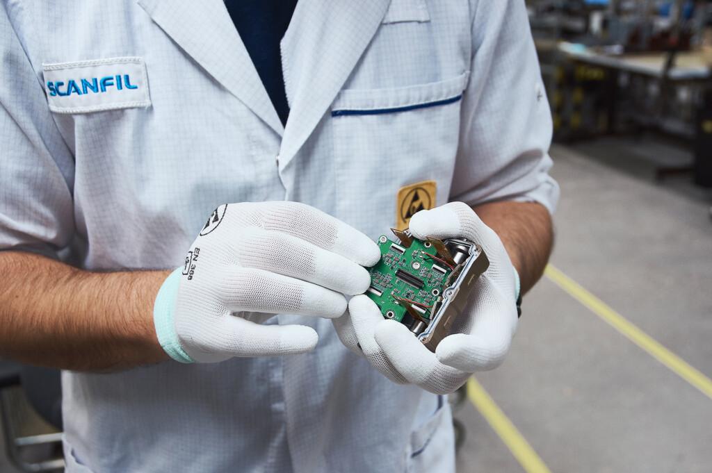 Scanfil employee presenting PCBA in Scanfil factory