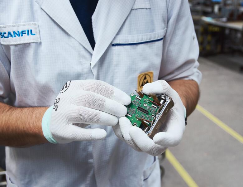 Scanfil employee presenting PCBA in Scanfil factory